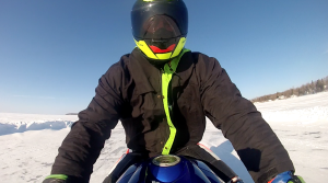 Snowmobiler Riding on Winter Lake