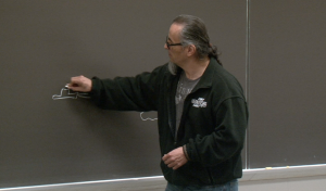 Adrian Liberty at Chalkboard While Giving Talk/Speech