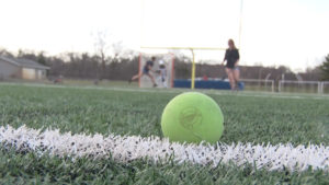 Lacrosse Ball on Field Players in Background