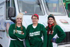 Slapshot team members, Annika Johnson, Michaela Johnson, Sheila Johnson, pose by their truck, as seen on The Great Food Truck Race, Season 11.